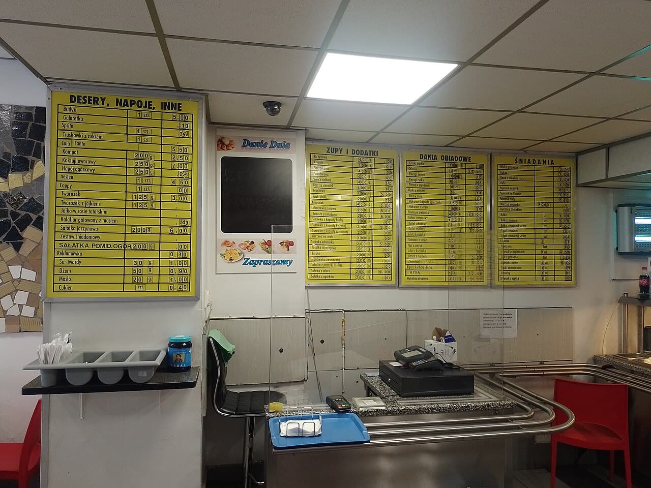Wnętrze baru mlecznego Europa w Katowicach: kasa, tablica z menu i samoobsługowy układ sali