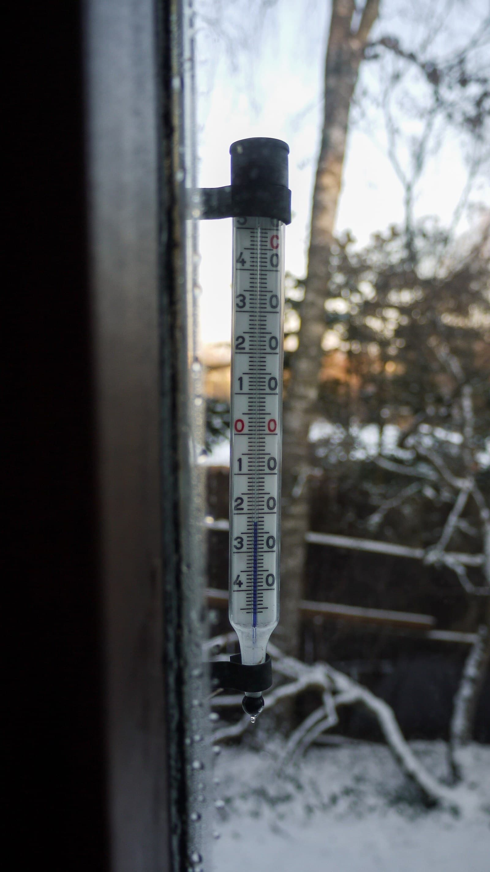 Termometr cieczowy na zewnątrz wskazujący około minus 22 stopnie Celsjusza, z długą kapilarą i skalą