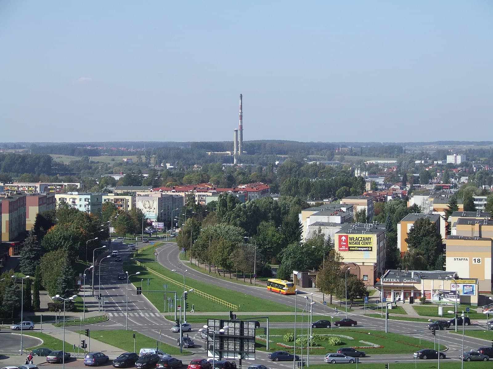 Widok z dachu bloku mieszkalnego w Łomży z kominami i instalacjami dachowymi