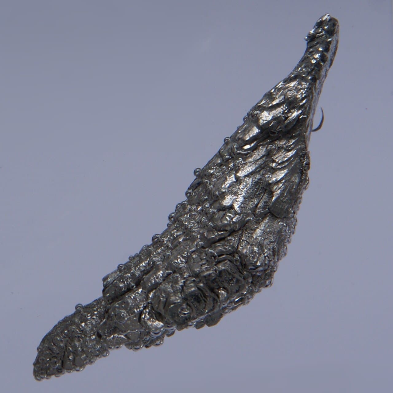 Srebrzystoszary kawałek metalicznego magnezu na ciemnym tle